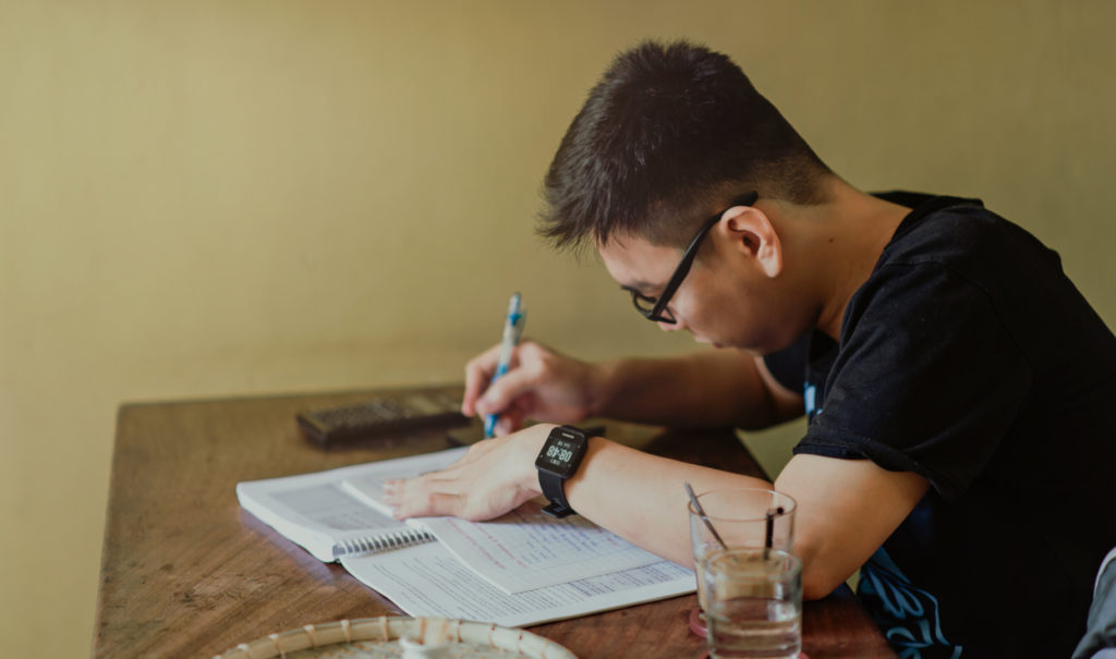 a man with glasses writing a personal statement